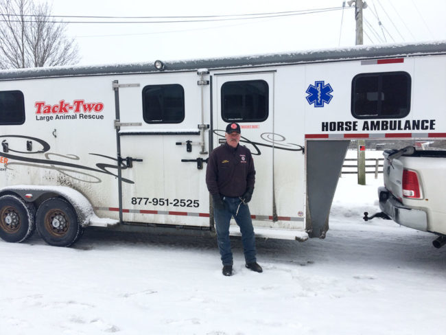 Man standing in front of a trailer that says "Horse Ambulance" and "Tack-Two, Large Animal Rescue" on it.