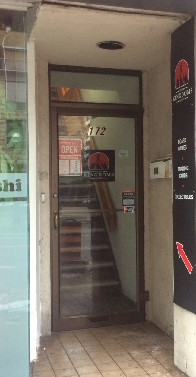 IMG_0030-02-03-20-06-28 a street image of the store entrance to three kingdoms games. There is a staircase behind the door that leads up to the store itself.