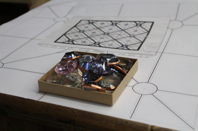 Large gems sitting in a small brown box. The box is sitting on a decorative countertop.