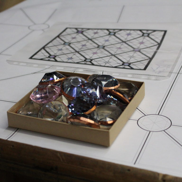 Large gems sitting in a small brown box. The box is sitting on a decorative countertop.