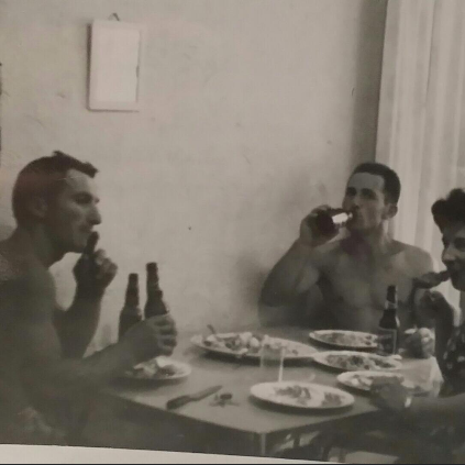 Black and white photo if a family sitting down for a meal together.