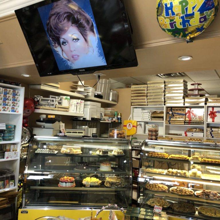IMG_2706 the interior of a bakery. The shelves are filled with various chocolates and baking ingredients, while the glass shelves in front have several baked goods sitting out for purchase.