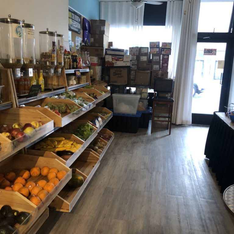 IMG_3477-1 Food in wooden bins. There are cardboard boxes at the back and lines of cereal dispensers against the wall.