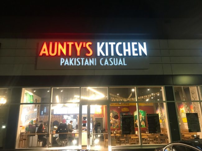 The storefront of Aunty's Kitchen. There are large windows that look into the interior of the store.