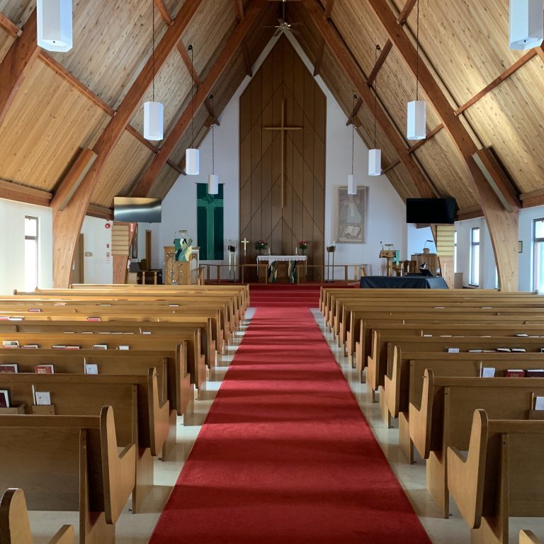 Church Pews Empty church pews, a red carpet on the floor, nature lighting through the aisles