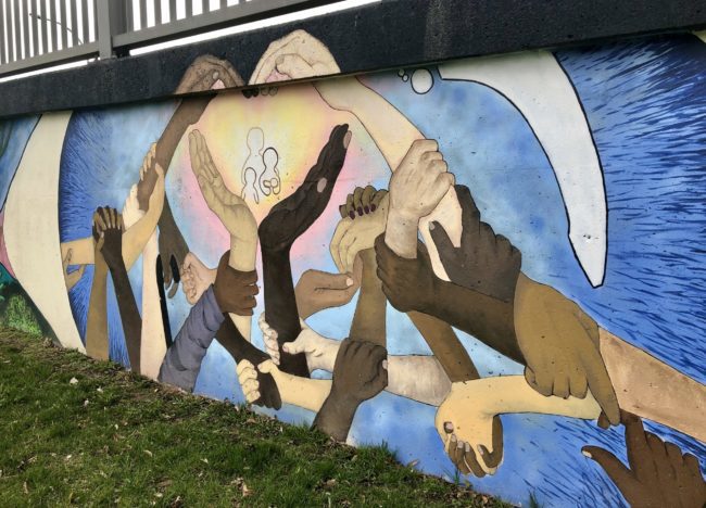 Mural of hands of different colors coming together and forming a heart.