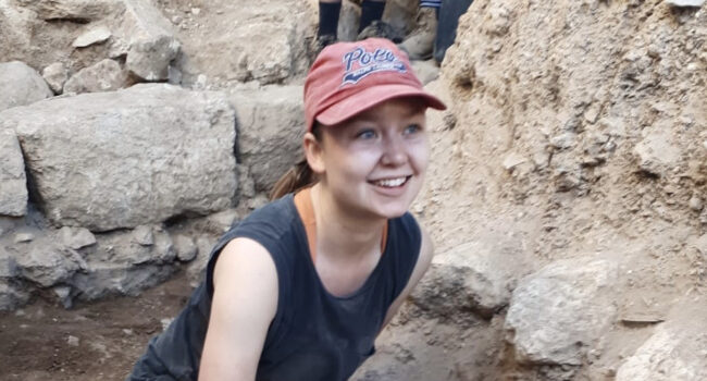 Woman in front of rocks.