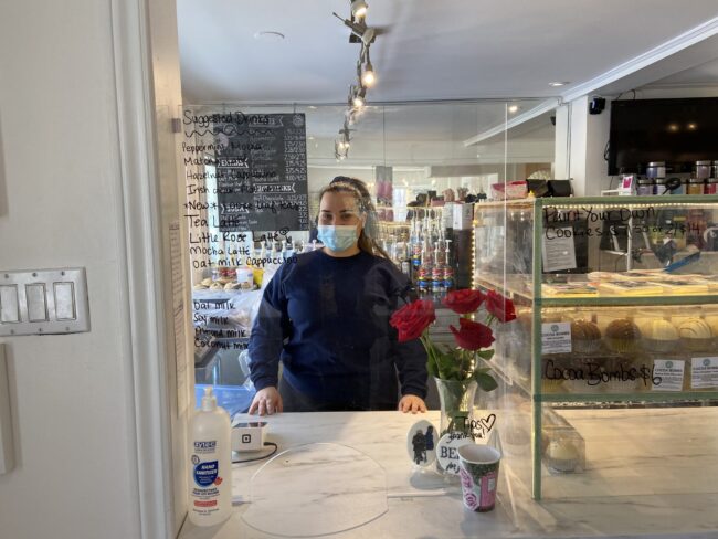Woman behind a counter in a bakery.