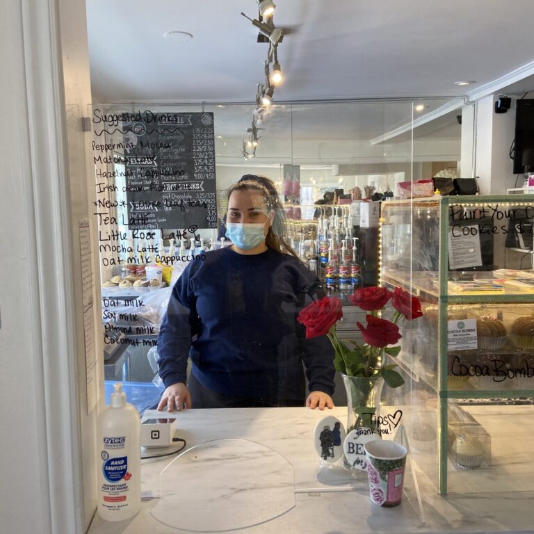 Woman behind a counter in a bakery.