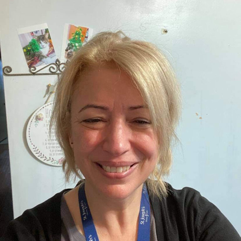 Blonde woman wearing a blue lanyard.