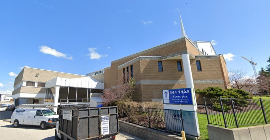 large church building and car road leading to back entrance 