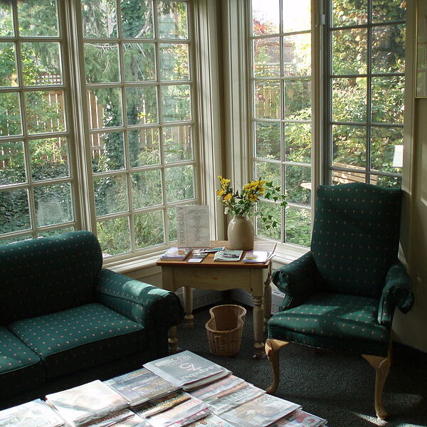 800px-ThornhillVillageLibrary4-2 Sitting area with a green couch and green armchair in front of a huge window.