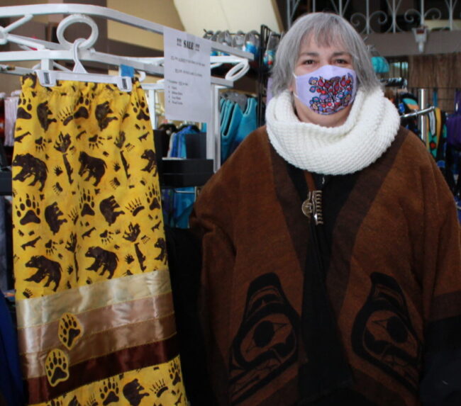 A woman stands next to a long skirt