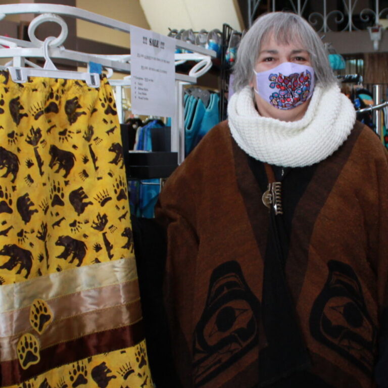 A woman stands next to a long skirt