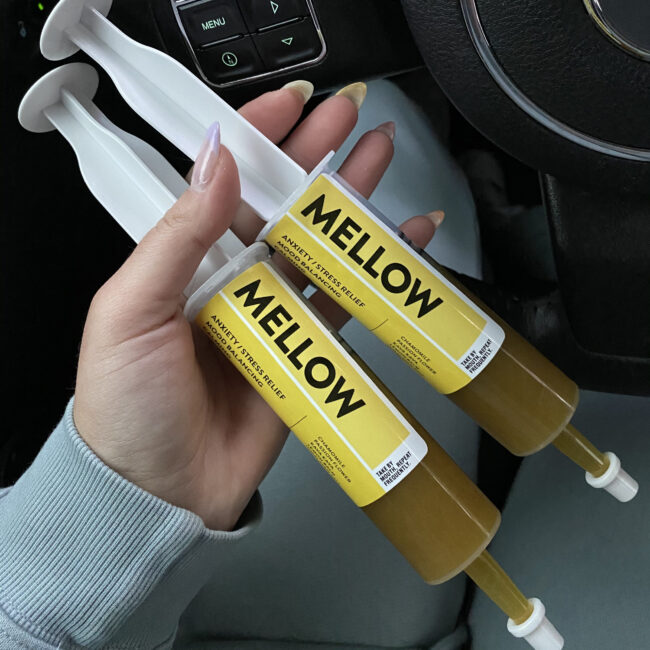 wo large non-medical syringes filled with a yellow substance.