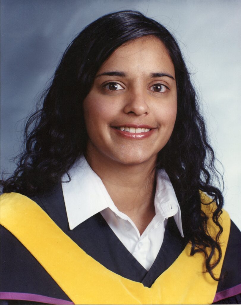 Somayajula wears a yellow cape over her black and purple gown.