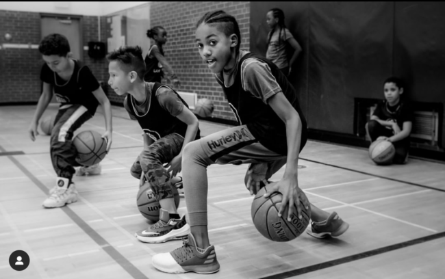 Boy dribbling a basketball in a school gym
