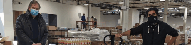 Two men standing in a warehouse.