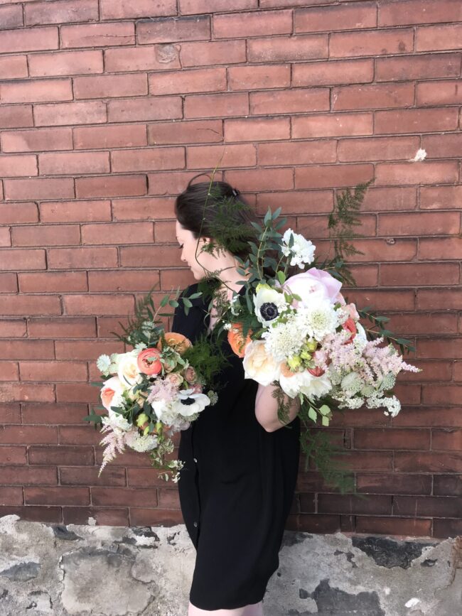 Women holding two flower bouquets.