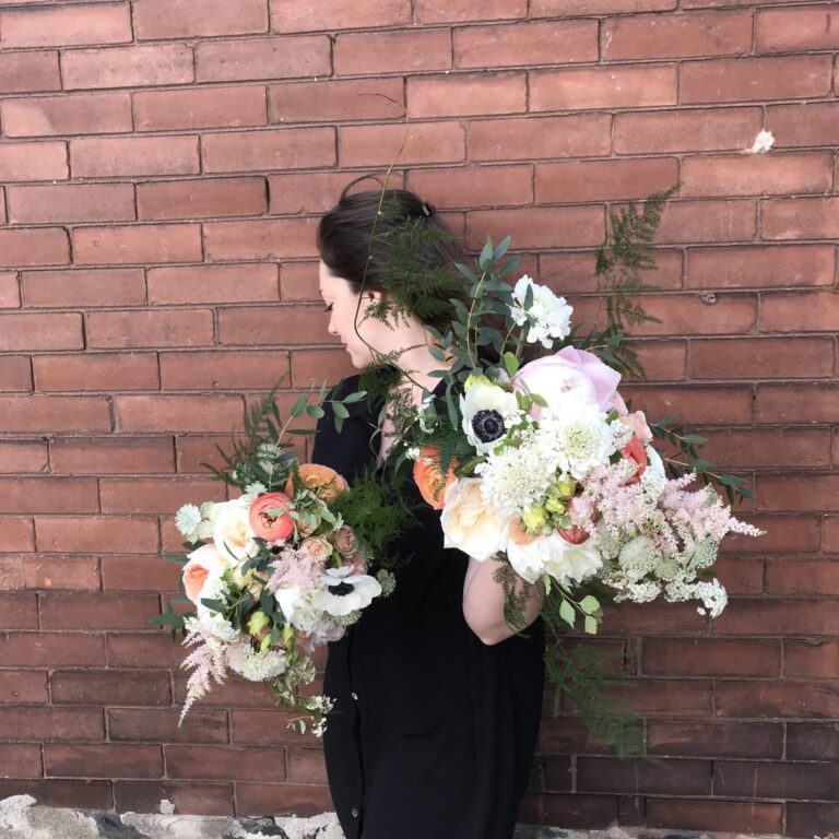 Women holding two flower bouquets.