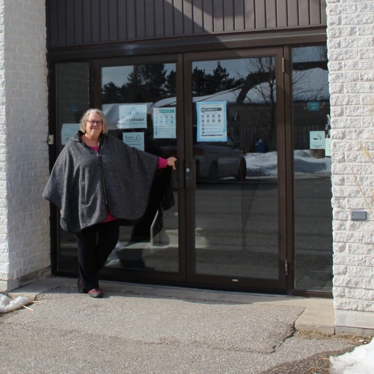 Lori Pilatzke holds the handle of St. David Anglican-Lutheran Church's glass front doors on a Sunny afternoon.
