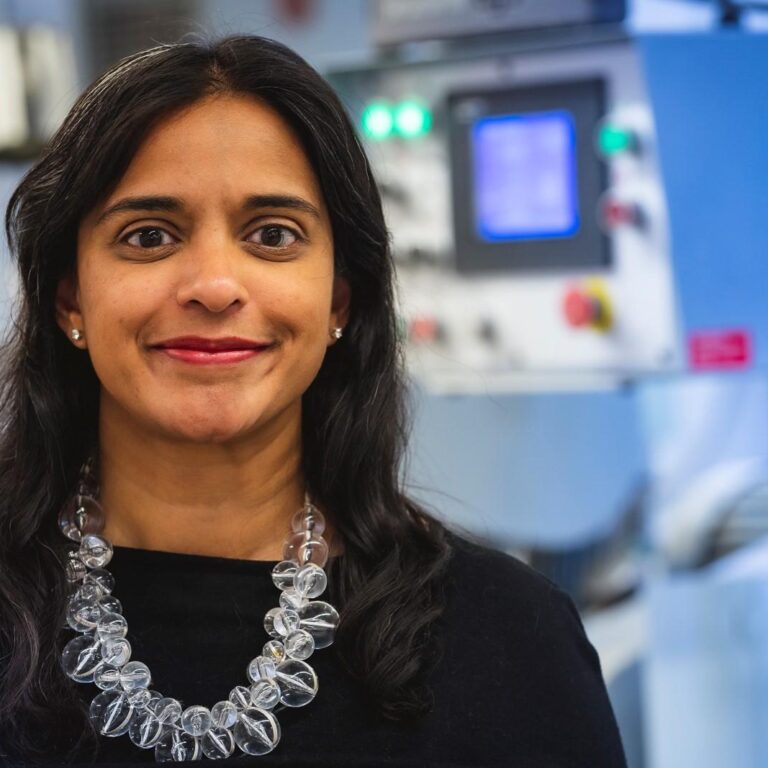 Women wearing a glass orb necklace smiling.