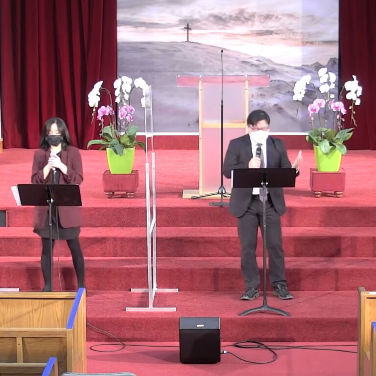 Band in black clothing performing on stage with transparent partitions between them.