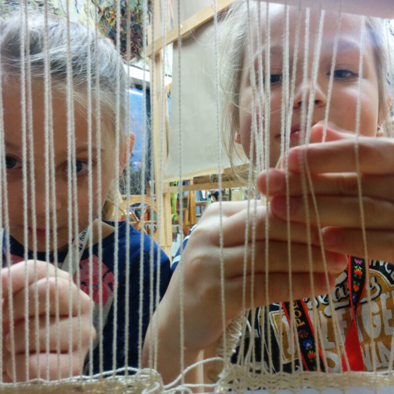 Two young girls weaving