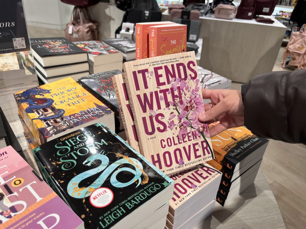 Hand holds book "It Ends With Us"