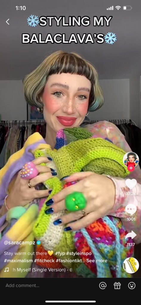 TikTok of a woman holding and armful of knit balaclavas showing how she styles them