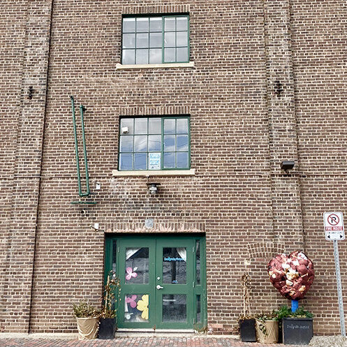 brown brick building with a bright green door