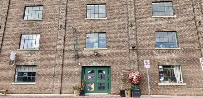 brown brick building with a bright green door