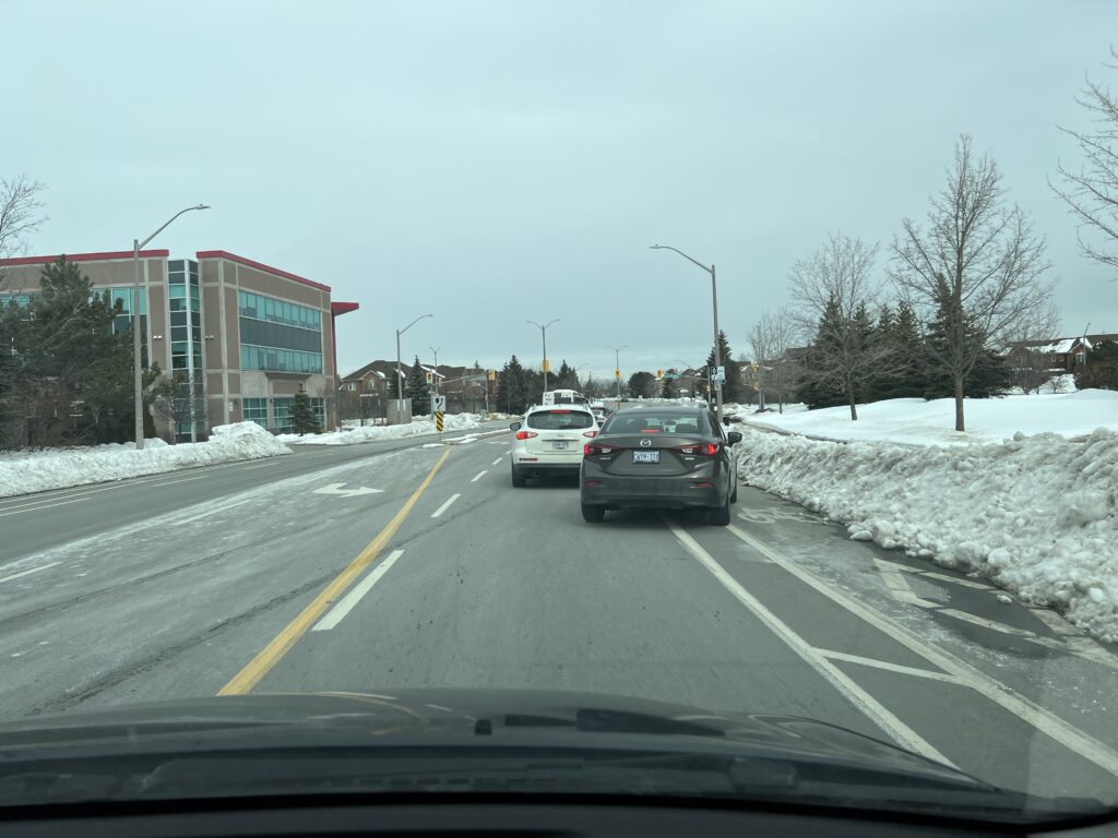Grey car switching lanes behind a white car