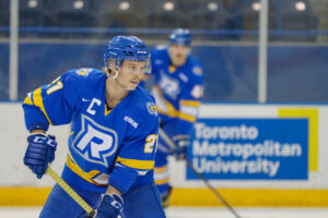 Hockey player skating on the ice with his stick in hand about to receive the puck