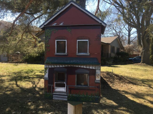A medium shot of a red Little Free Library