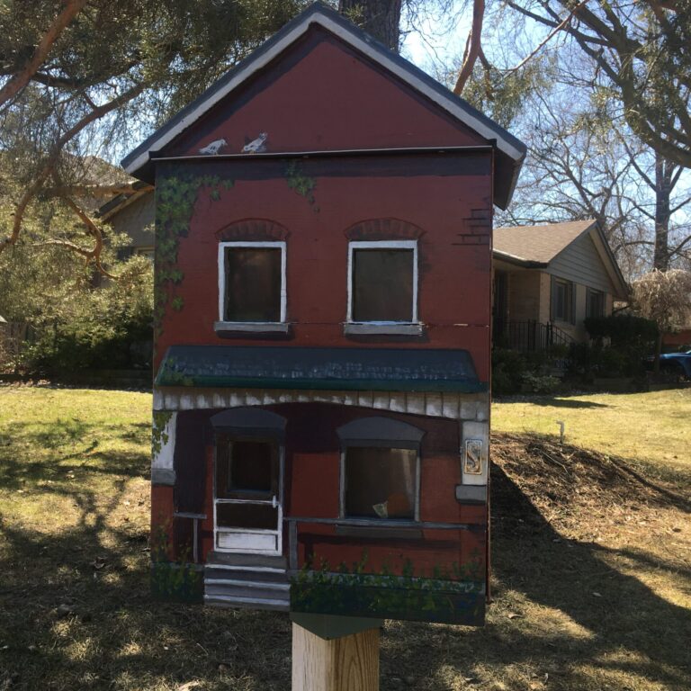 A medium shot of a red Little Free Library