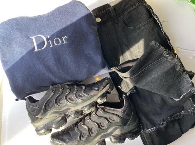 custom Dior crewneck in navy blue with black jeans and black sneakers.