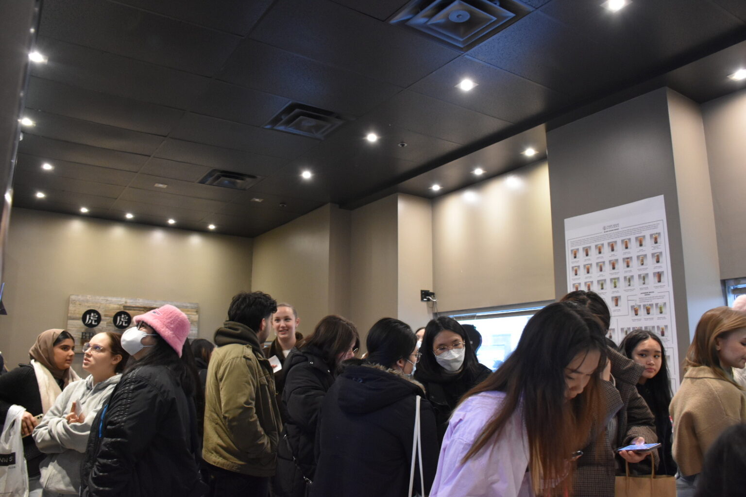 K-pop fans crowd the interior of a local bubble shop to converse with local vendors and purchase bubble tea drinks