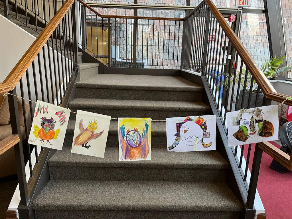 Staircase with art work hanging on the railings.