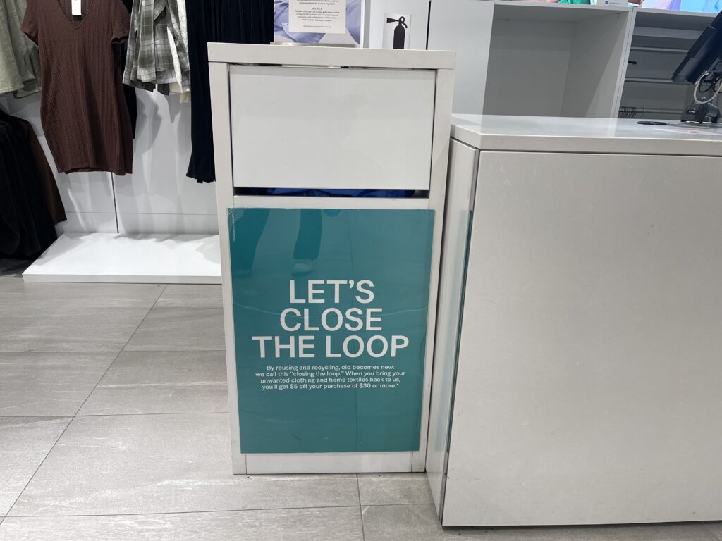 Photo of a donation box at H&M that reads, "Let's Close the Loop."