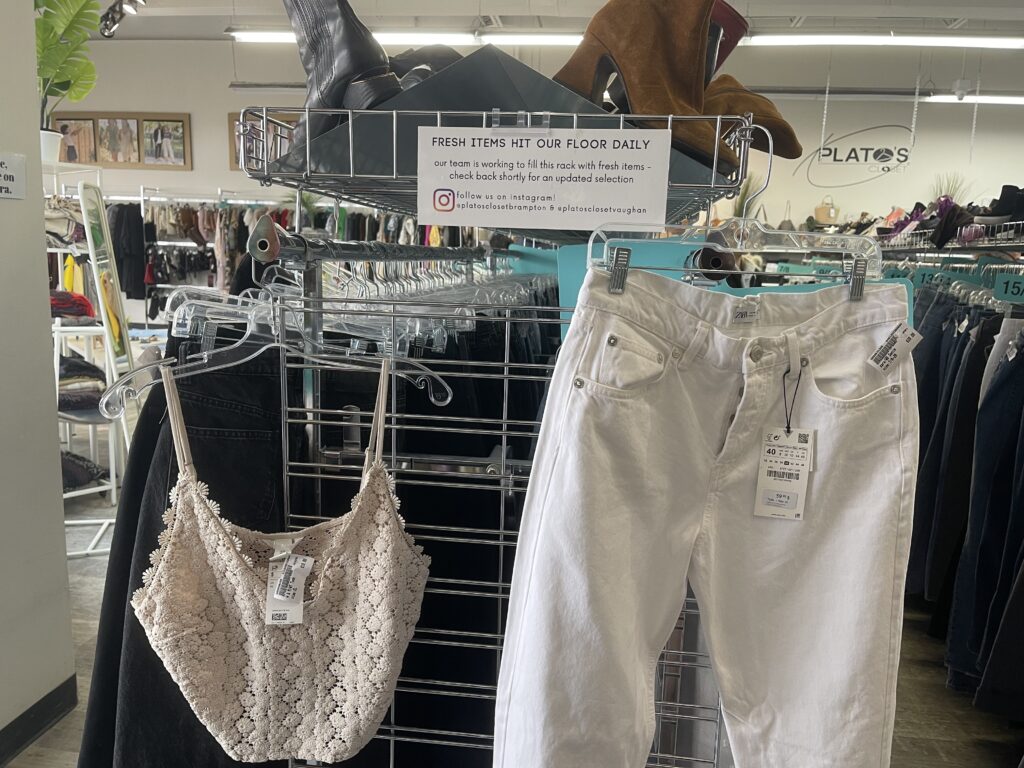 A photo at Plato's Closet. There are white jeans and a crochet top.
