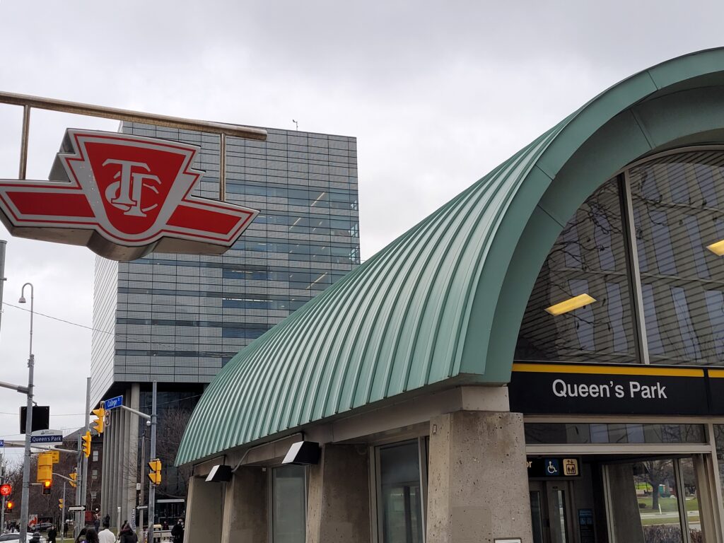 A TTC sign hangs over Queens Park subway station