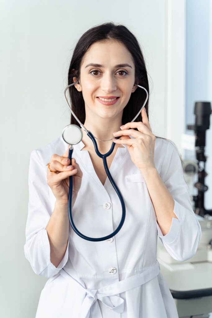 A doctor smiling while holding a stethoscope