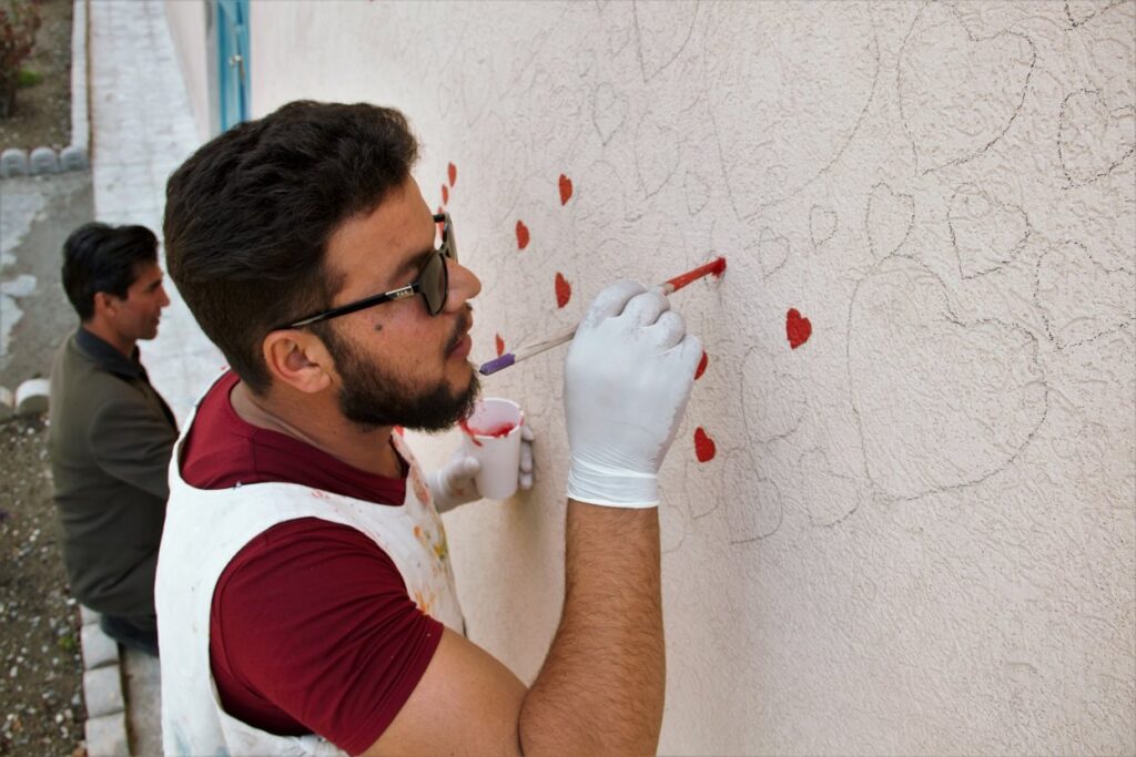 A man painting on a canvas.