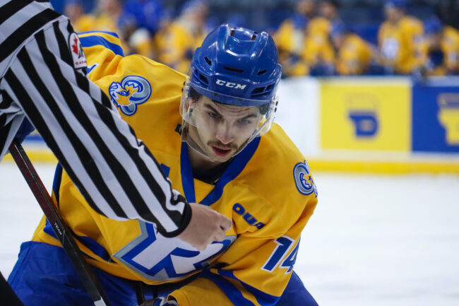 Hockey player getting ready to get the puck before the referee drops it