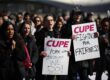 CUPE members holding signs with emotional facial expressions.