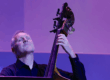 Man closing his eyes while playing an acoustic bass