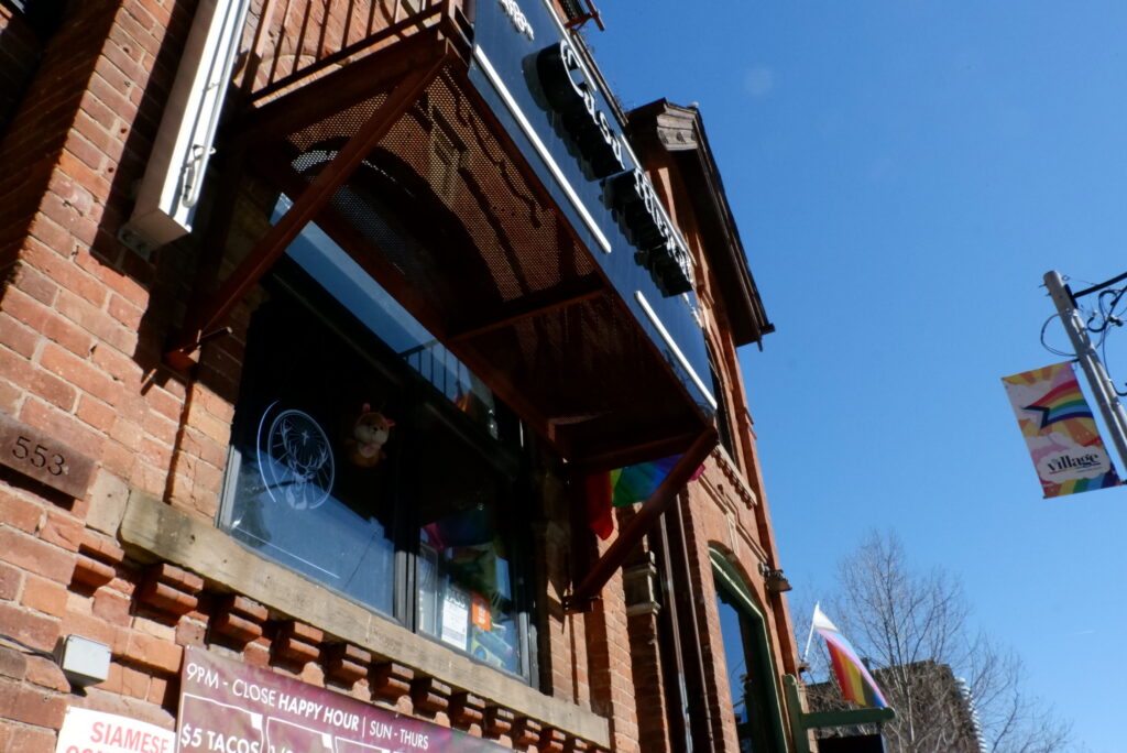 The front of Casa Mezcal bar: a red brick building with a black sign