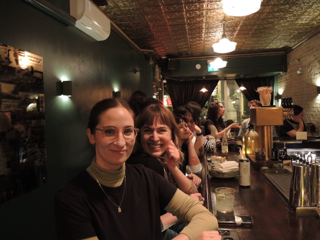 Group of women and other people sit at a bar