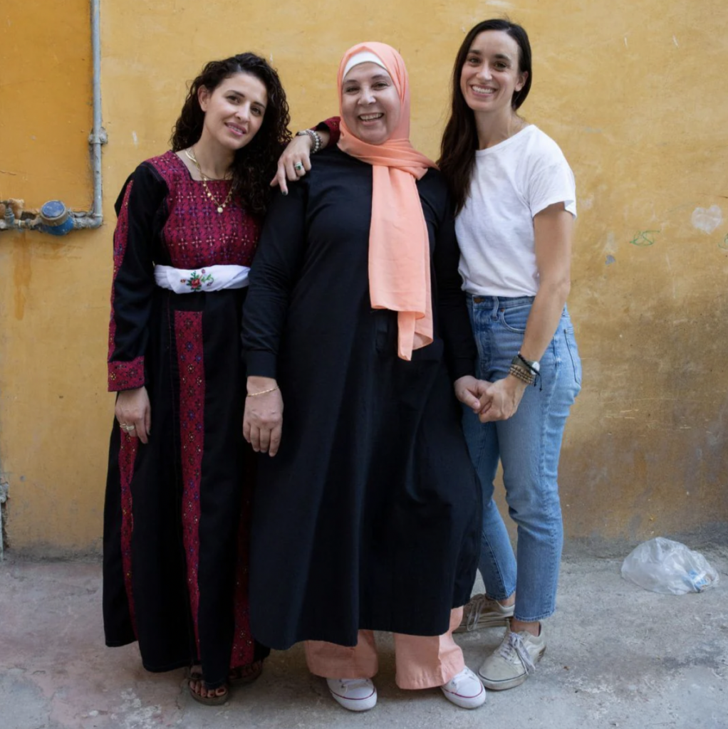 Image of three smiling women standing together, co-founders of Sitti.